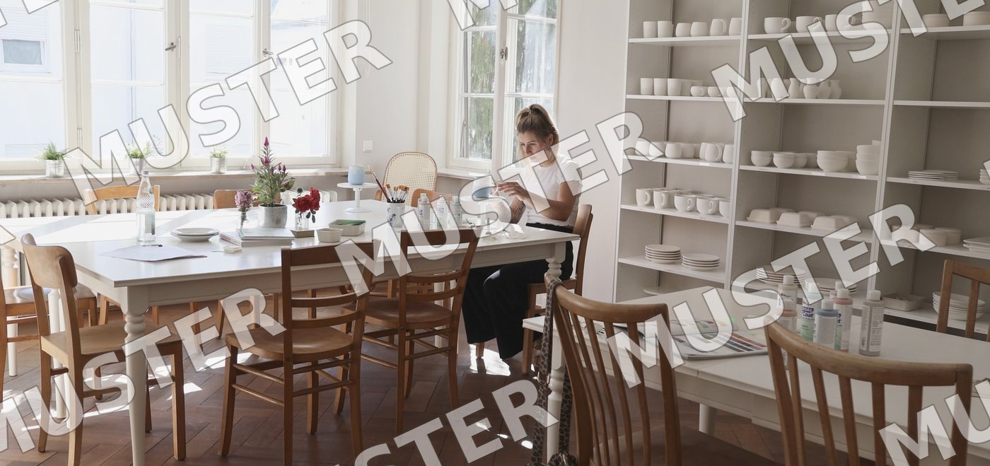 Gutschein Vorderseite: das helle Atelier MARIE mit Regalen voller Keramik